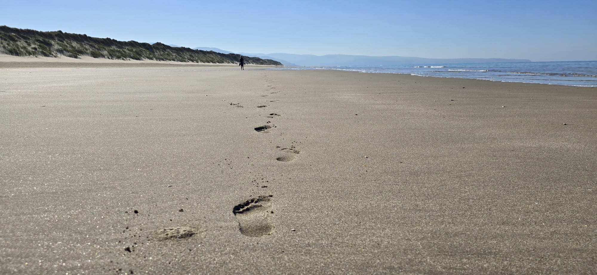 Footprints along an empty beach